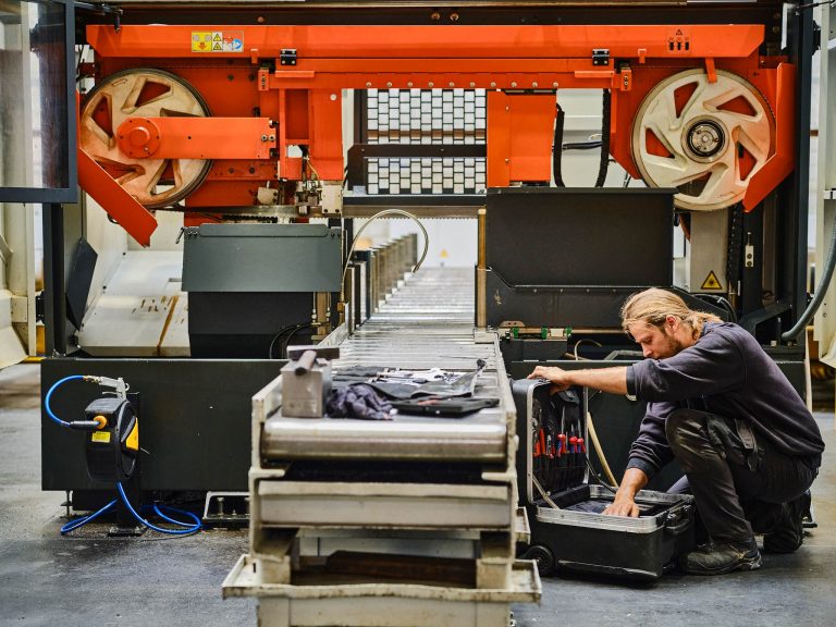 Techniker repariert Werkzeugmaschine bei Optimo Technics